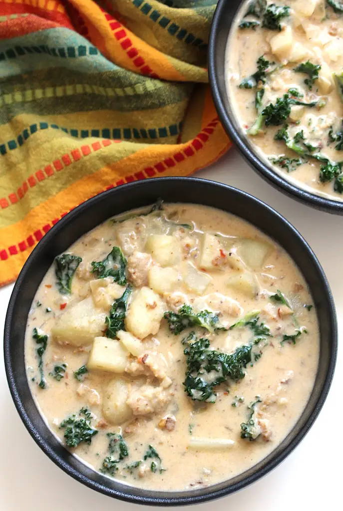 picture of two bowls with vegan creamy potato sausage kale soup