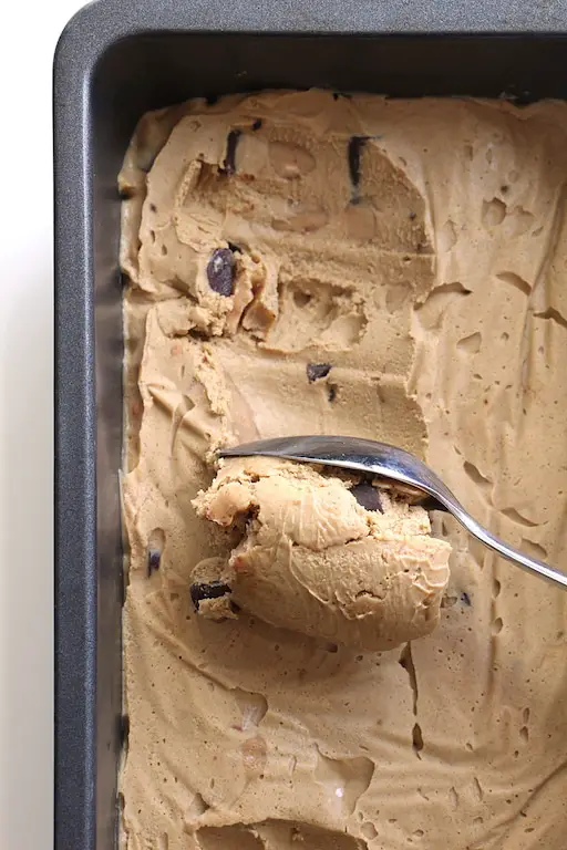 Image of vegan coffee ice cream being scooped from a loaf plan
