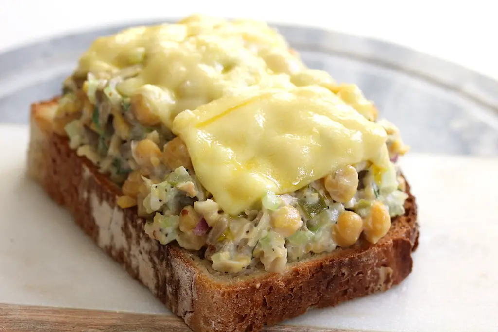 open faced vegan chickpea salad sandwich with melted cheese