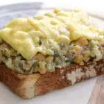 open face chickpea salad sandwich with melted cheese