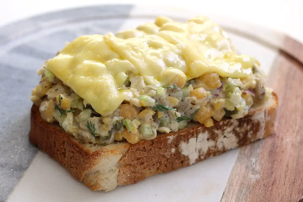 open face vegan chickpea salad sandwich with melted cheese