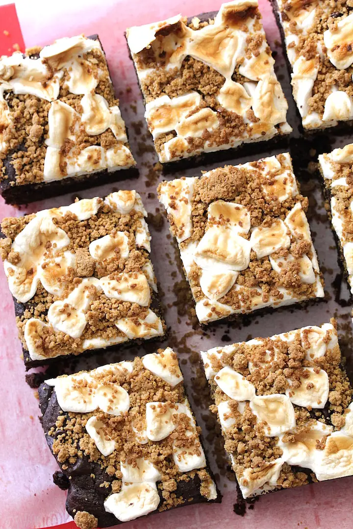 Squares of Vegan Gluten-Free S'mores Brownies arranged on a red cutting board