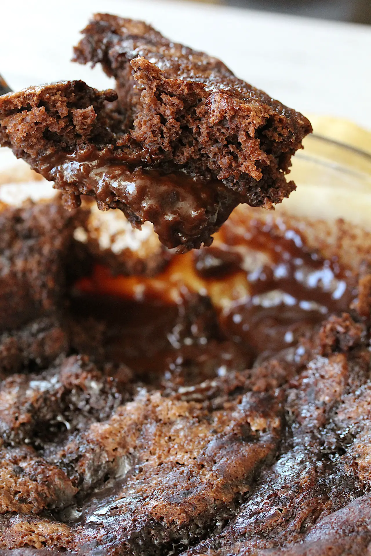 gluten-free chocolate pudding cake being spooned out of a dish