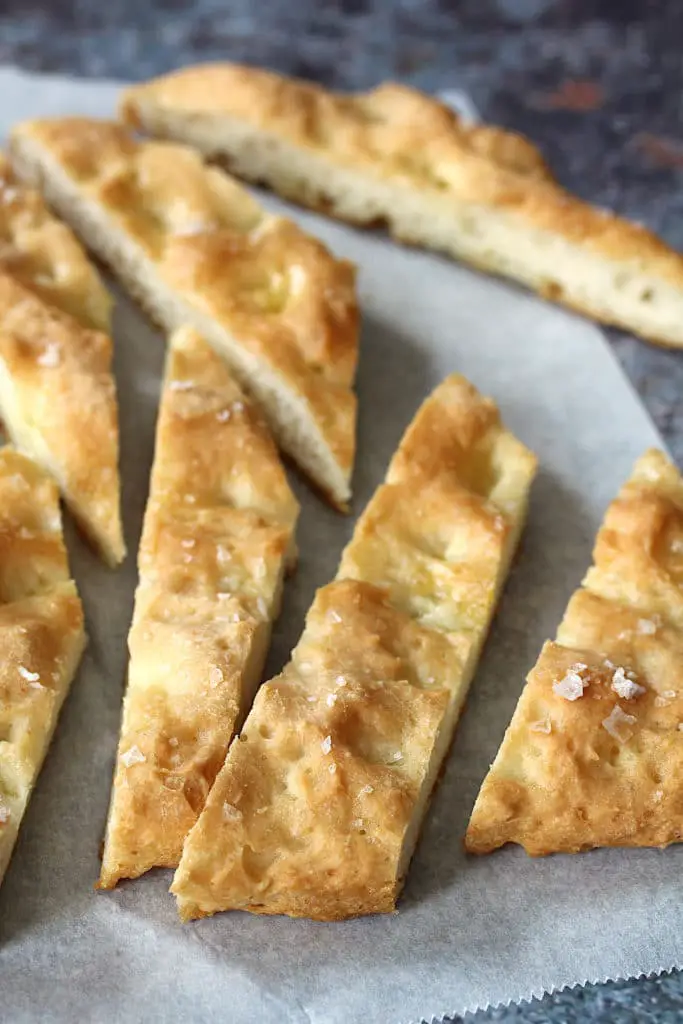 image of the delicious gluten-free vegan focaccia bread recipe sliced into strips and on parchment paper.
