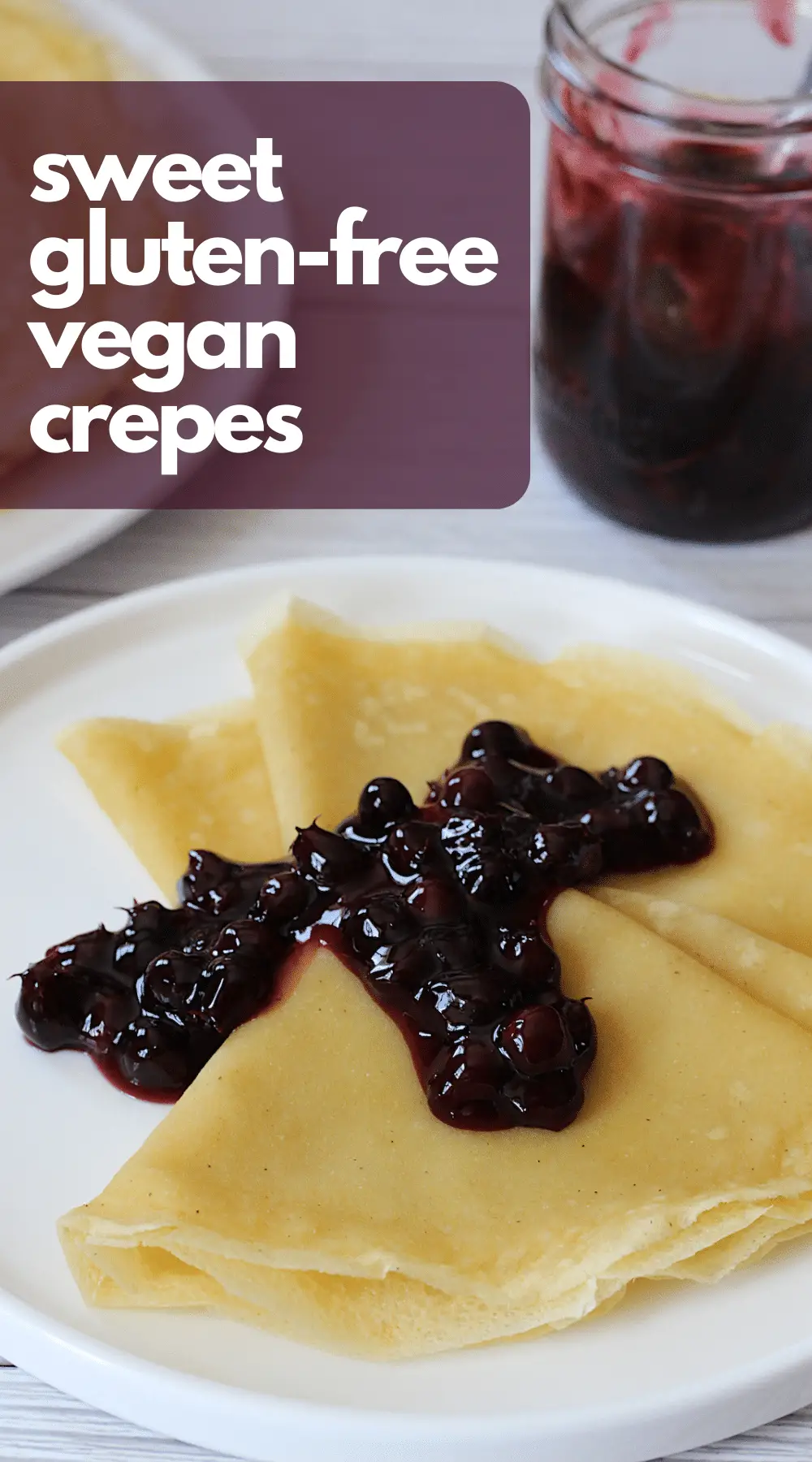 Pinterest pin. Image of folded crepes on a white plate, topped with Saskatoon berry sauce. A jar of Saskatoon berry sauce is in the background. On the top left of the pin there is text overlaid on a purple background. The text reads sweet gluten free vegan crepes.