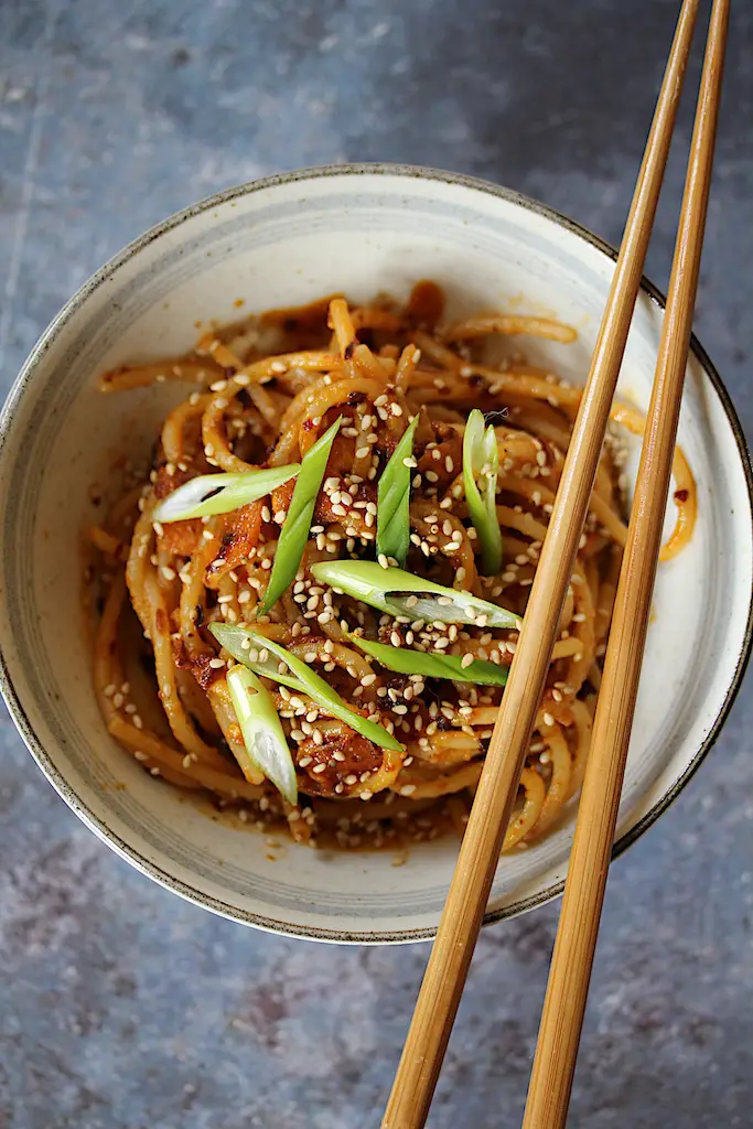 Image of this 1-serving chili crisp noodles in a bowl with chopsticks on the side of the bowl