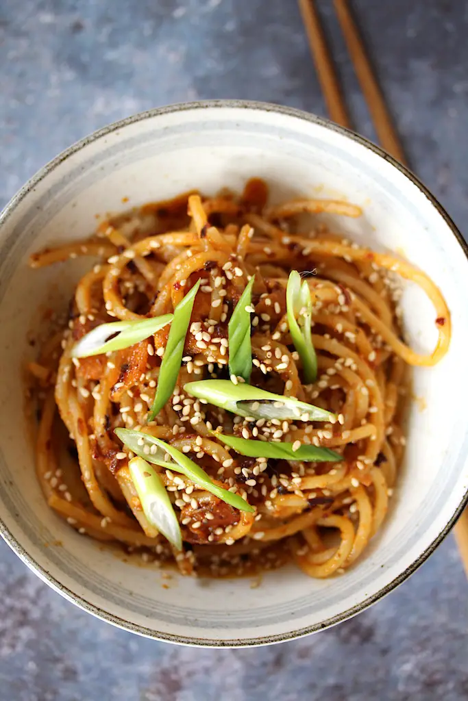 Image of this 1-serving chili crisp noodles in a bowl with chopsticks to the side.